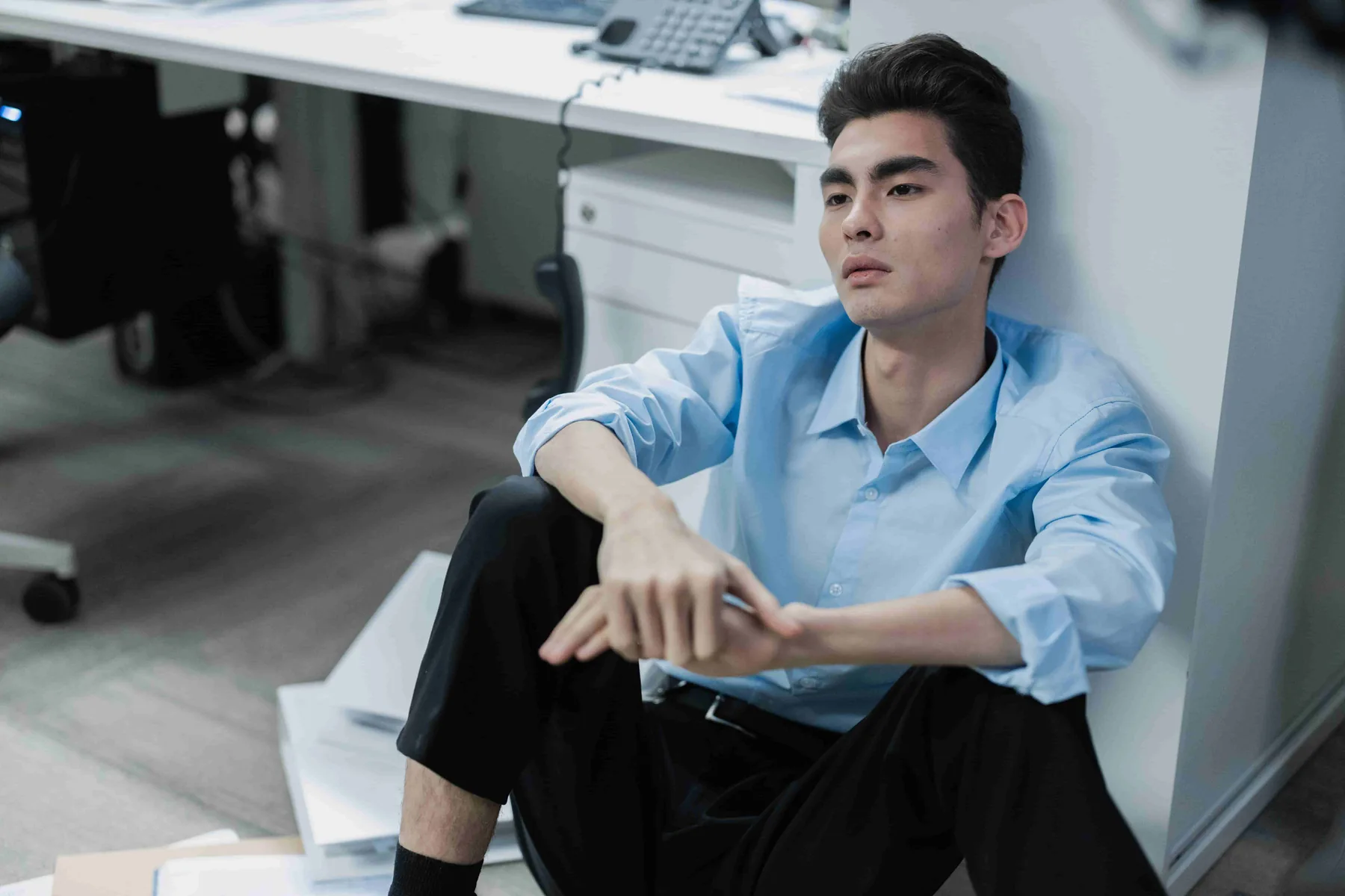 A man in a blue shirt sitting at home
