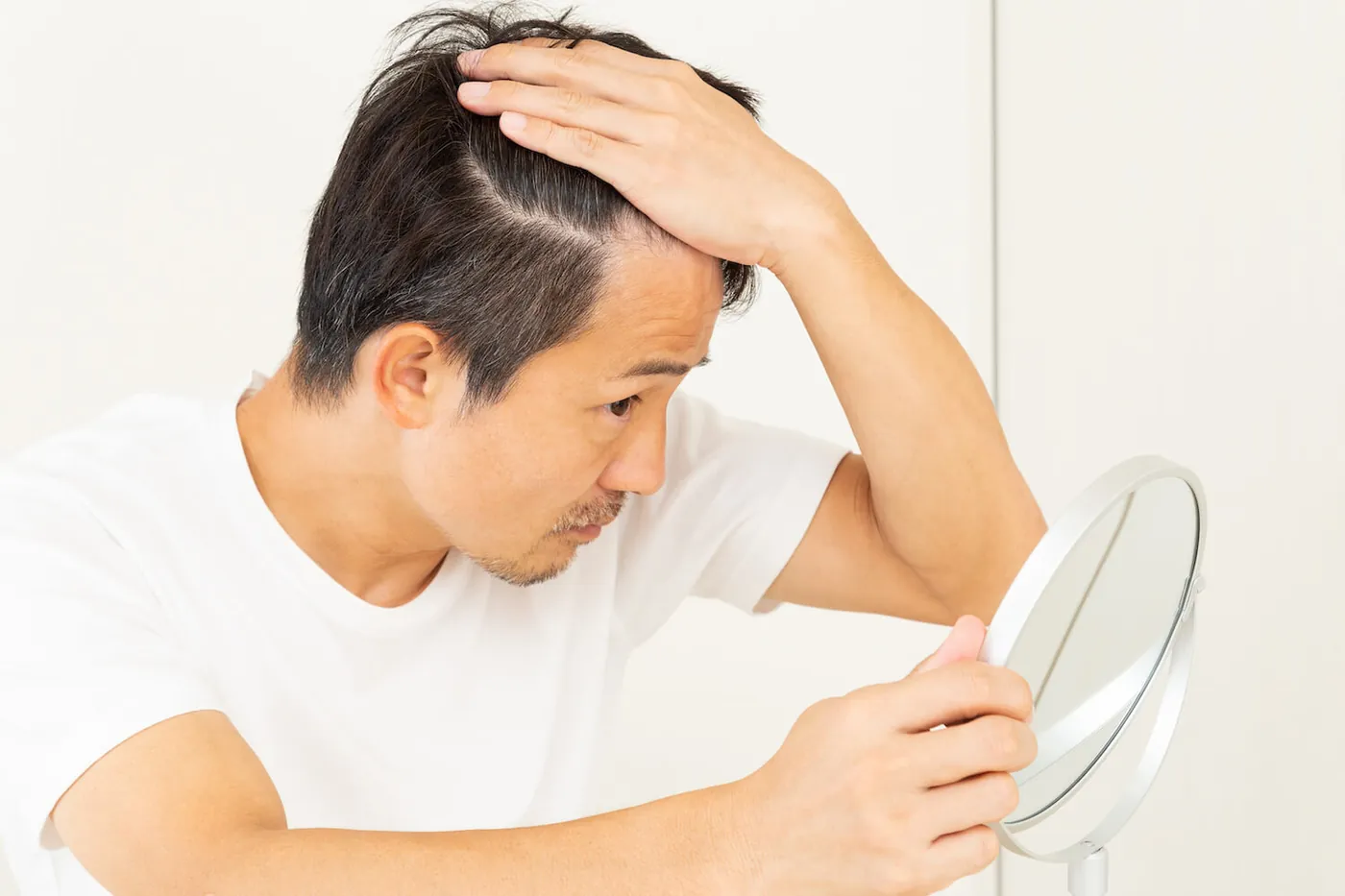一名男士摸著自己的頭髮